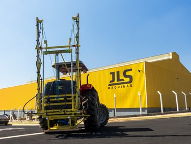 Pulverizador agrícola JLS Nadja 0.6k com a fábrica da JLS ao fundo