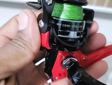 molinete pequeno albatroz para lambari mao segurando o molinete vermelho com preto