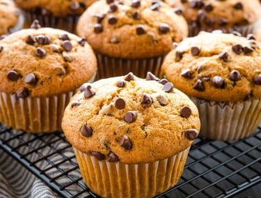 Freshly baked pumpkin chocolate chip muffins cooling on a wire rack.