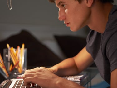 imagem mostra um jovem estudando com seu notbook.