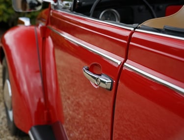 Detalle puerta cromada del Volkswagen Beetle Cabriolet rojo 1971, clásico elegante de alquiler para bodas.