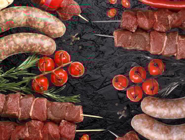 Assortiment Viande halal crue : brochettes de bœuf, merguez et saucisses avec tomates cerises.