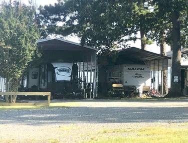 camper trailers under a metal canopy awning