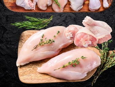 Poulet halal cru : filets, cuisses et morceaux avec herbes fraîches sur planche.