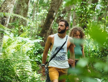 Couple walking along a nature trail in the lush Jozani Forest Zanzibar tropical rainforest