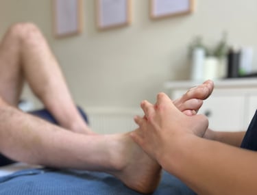 foot being assessed by practitioner as part of reflexology treatment