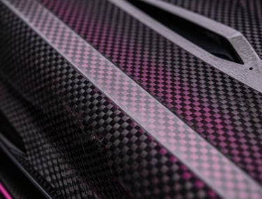 Close-up of a high-tech carbon fiber surface with magenta light catching the weave, representing elite engineering and premium design.