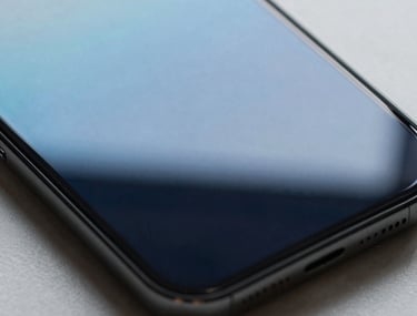 An artistic shot of light reflecting off a glass smartphone screen, creating a beautiful gradient of sky blue and deep navy.