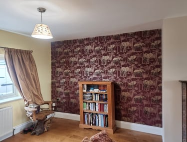One feature wall covered in red wallpaper with an elephant motif.