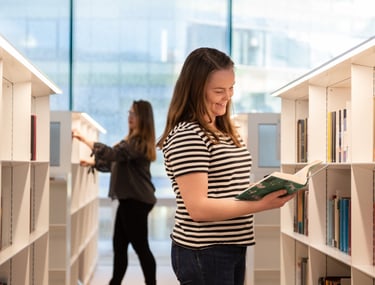 Lehdistökuva tytöistä lukemassa kirjaa Oodi kirjastossa Helsingissä