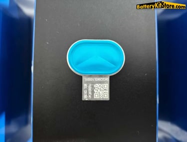 a battery cell with a blue pressure relief valve and a QR code