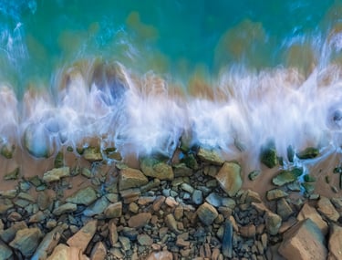 a wave crashing over rocks and rocks