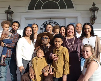 large family in from of white residential home