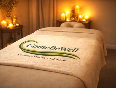 Candlelit healing room with a massage table draped in softness, inviting rest and renewal