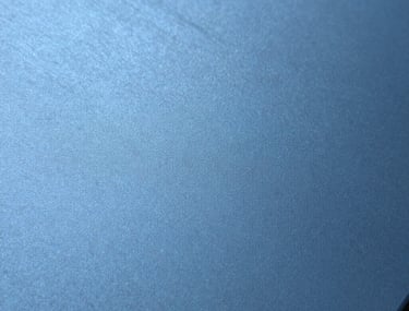 Close-up detail tekstur aluminium berwarna biru matte yang elegan, menunjukkan kualitas finishing permukaan yang sangat halus dan mewah.
