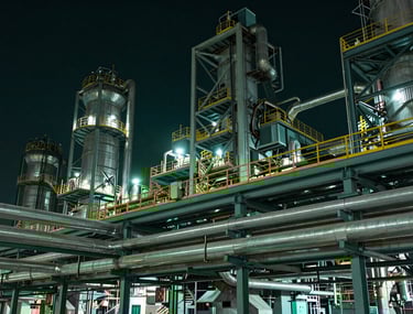Industrial night photography of a clean, modern steel mill, focusing on geometric patterns of pipes and structures, low key lighting with deep green hints.
