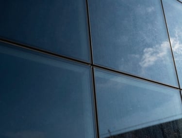 Abstract photography of light reflecting on glass, shades of deep navy and steel blue, symbolizing clarity and analysis.