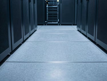 Clean, minimalist photography of a server room floor with low-angle perspective. Cool bright blue light reflecting on polished grey floors. Technical precision.