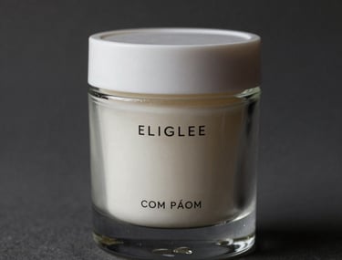 Primer plano de alta calidad de un envase de cosm&eacute;tica de vidrio esmerilado con tipograf&iacute;a minimalista en gris oscuro. La iluminaci&oacute;n es cinematogr&aacute;fica, destacando texturas limpias y una paleta de colores en blanco hueso y carb&oacute;n.