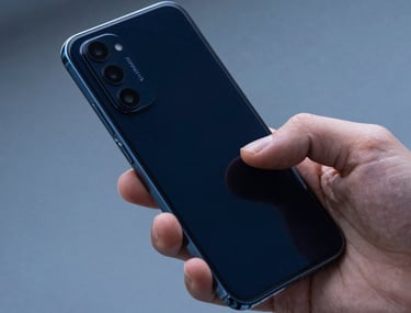 Close-up photography of a professional hand interacting with a modern Android smartphone. The lighting is crisp and cool-toned, reflecting a deep navy blue and muted blue environment in an Eastern European tech hub. Focused on the fluid movement of the interaction.