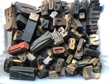 Printer's wood block letters in a bin.