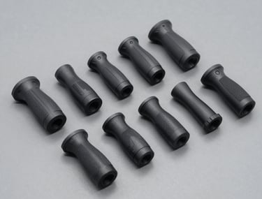 A series of 3D-printed ergonomic prototypes for a handheld tool, arranged neatly on a mid-gray surface. Each prototype shows a different iteration of grip geometry.