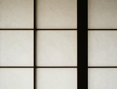 Abstract photography of light and shadow on a traditional shoji screen. Minimalist composition in off white and black.