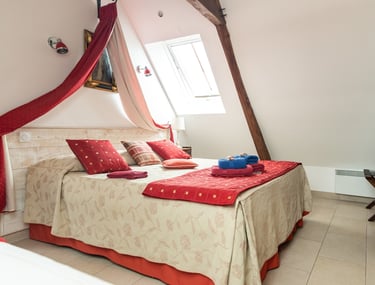 Chambre lumineuse et ensoleillée avec un grand lit king-size.