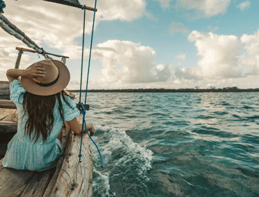 Una mujer en un velero navega mirando el horizonte