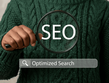 Hand holding a magnifying glass over the word SEO with an optimized search engine bar.