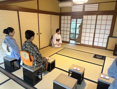 Woman in a kimono seated in a traditional Japanese tea room
