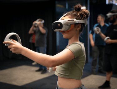 Young girl wearing a VR headset and holding VR controllers playing VR games
