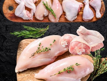 Poulet halal cru : filets, cuisses et morceaux avec herbes fraîches sur planche.