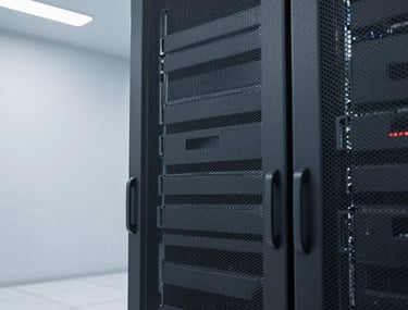 A sleek, dark gray server rack in a brightly lit, clean data center environment.