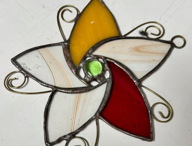 Stained glass flower with petals of amber, scarlet, and ivory made by Rochard MacDonald