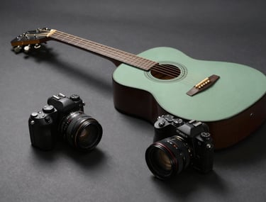 Minimalist composition of a guitar and a camera on a dark gray surface, cinematic lighting from the side, sage green accent.