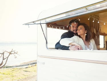 Mariés regardant le lac Léman depuis la fenêtre de la caravane photobooth.