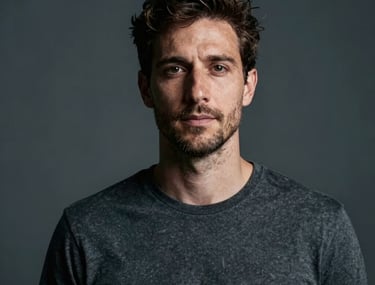 A minimalist studio portrait of a Southern European / Portuguese artist. Soft charcoal background, dramatic side lighting using cool tones. Professional photography.