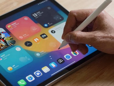Action shot of a digital stylus being used on a high-end Android tablet. The screen shows a vibrant, layered interface mockup. North American / US design environment.