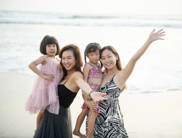 Two mothers and children during joyful family photography session at Padma Resort Legian Bali by the beach.