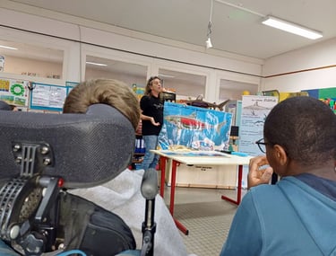 Alain Surina qui explique la flottabilité des requins à des enfants handicapés