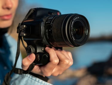 mujer sosteniendo una camara con lente