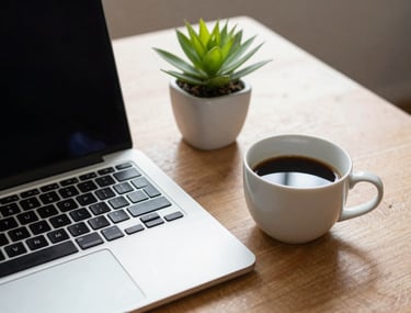 A professional desk setup featuring a laptop and a neatly placed coffee cup. A small green plant adds a touch of life. The scene conveys a sense of calm efficiency and modern work-life balance. North American / US home office.