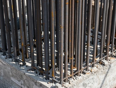 Close-up of high-strength steel rebar and concrete foundation work at a massive North American infrastructure project, showcasing the fundamental reliability of Mazeej engineering.