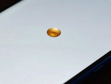 Macro shot of an Android device screen showing a high-fidelity prototype. The colors are ice white and navy blue, with a single amber gold button. North American / US context.