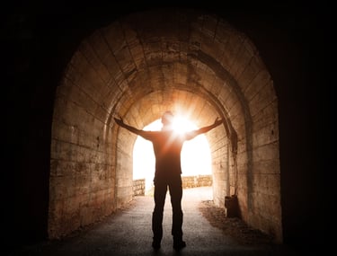 Persona avanzando hacia la luz como símbolo de acompañamiento y crecimiento personal