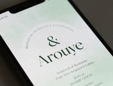Clean shot of digital invitation designs on a smartphone screen, showcasing elegant serif fonts and a minimalist layout in soft green tones.