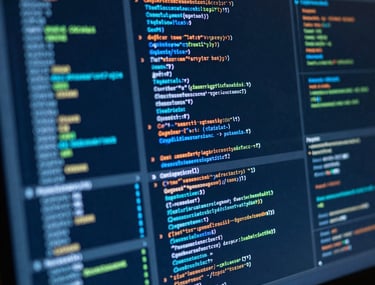 Close-up of a high-resolution screen displaying cybersecurity codes and data analytics charts. Technical, sharp, blue glow, professional.