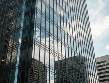 Creative shot of a glass office building in a South American business district reflecting the sky. Professional, corporate, ambitious tone.