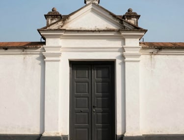 A minimalist, artistic shot of a Mumbai heritage building doorway against a clean, clear sky, representing the blend of tradition and modern creativity.
